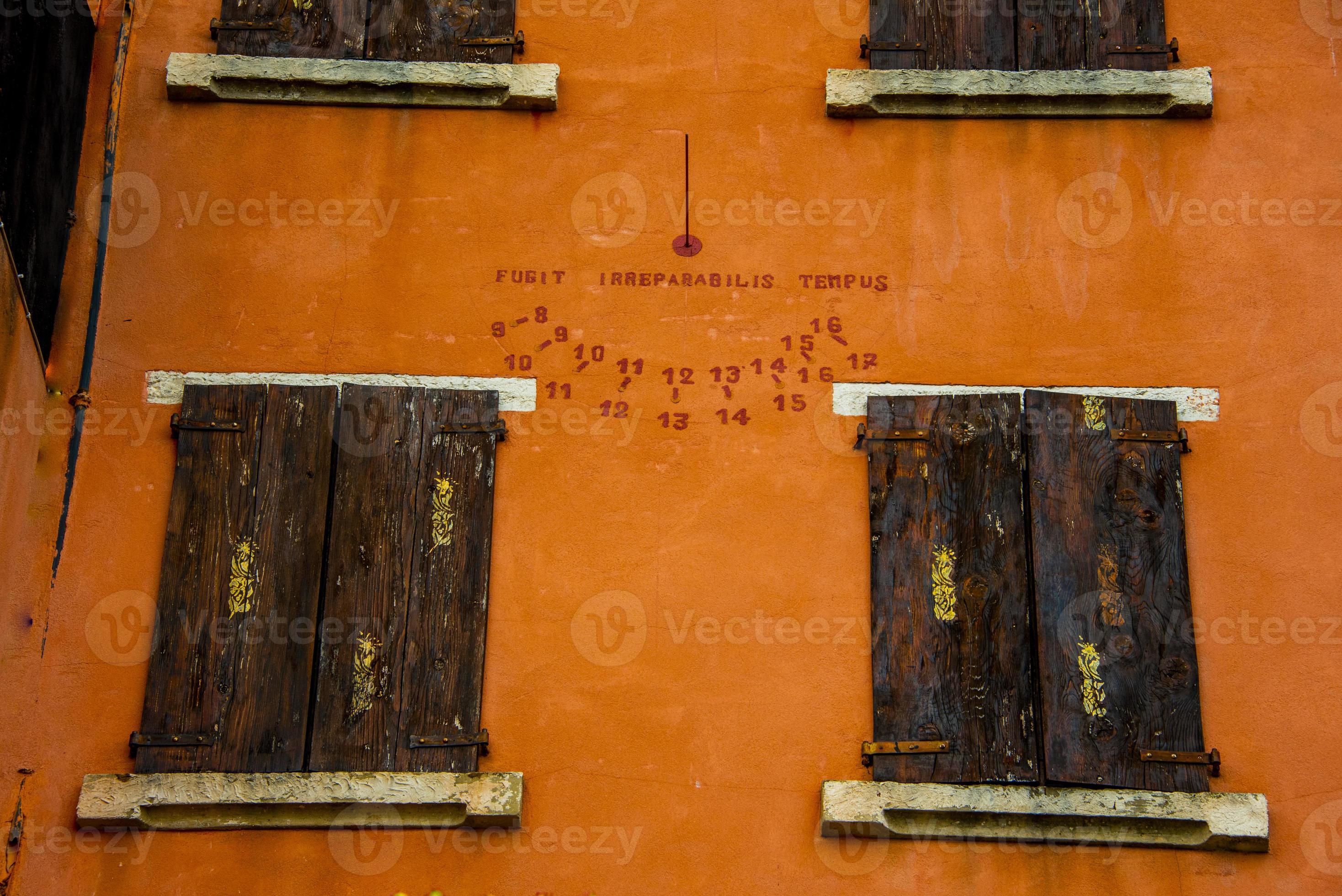 Menda City Masaccio Leugen zonnewijzer op oranje muur 2488262 Stockfoto