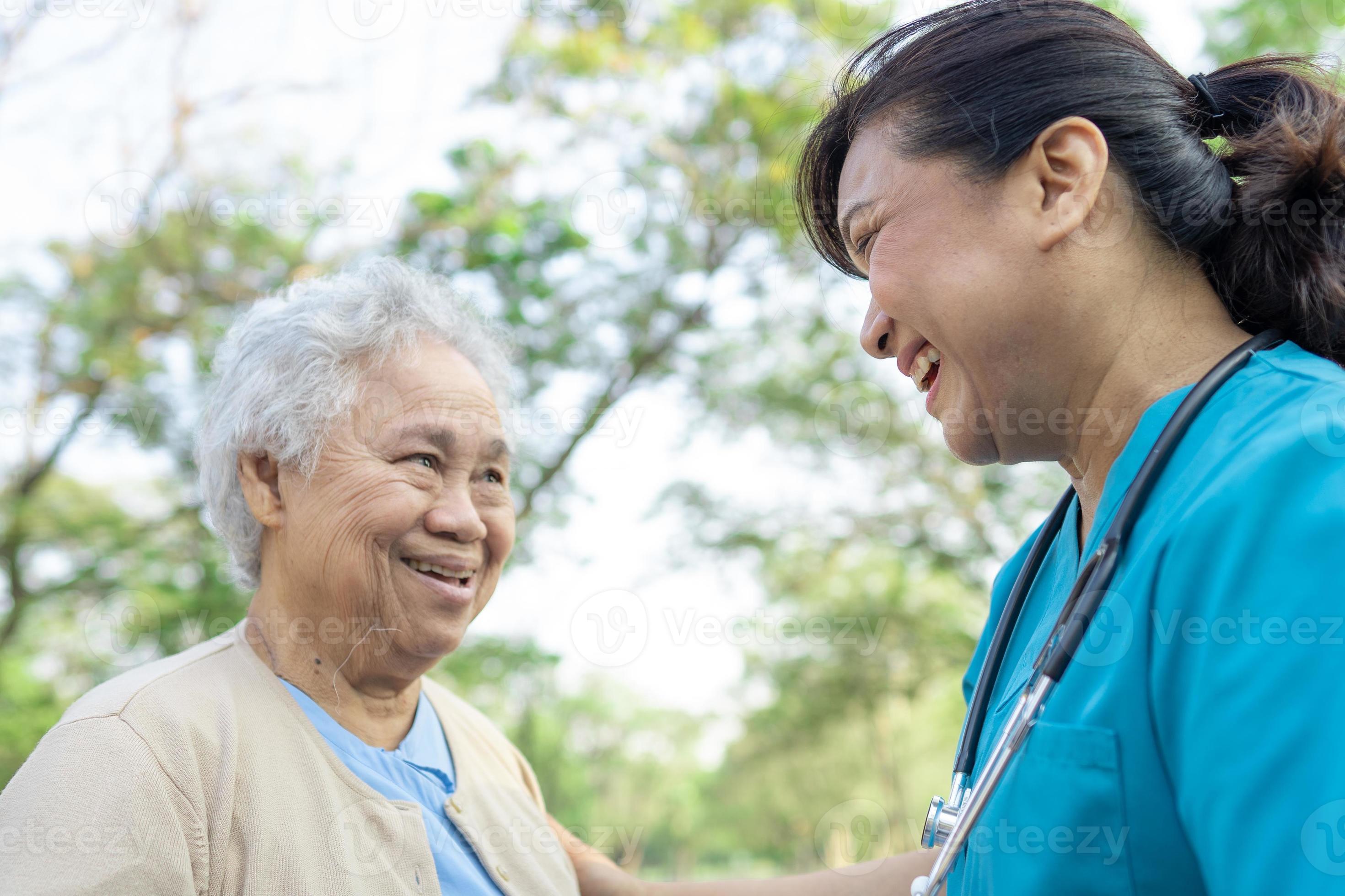 dokter helpt en verzorgt aziatische senior of oudere oude dame vrouw met een sterke gezondheid tijdens het wandelen in het park in een fijne frisse vakantie. foto