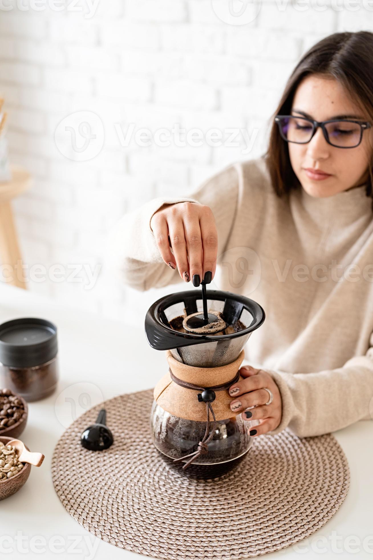 vrouw zet koffie in koffiepot en giet heet in het filter 3220939 Stockfoto