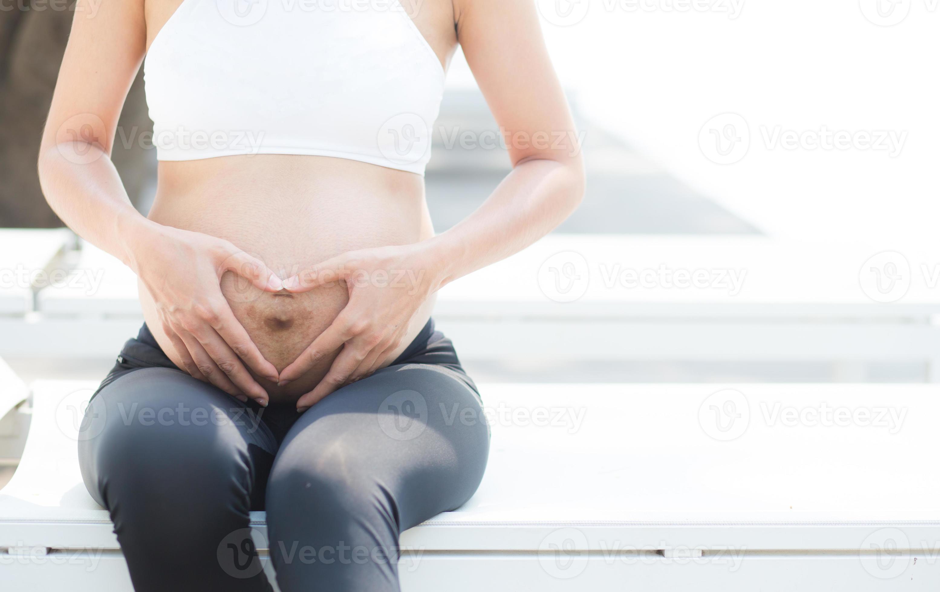 zwangere Aziatische jonge vrouw ontspannen in het park. foto