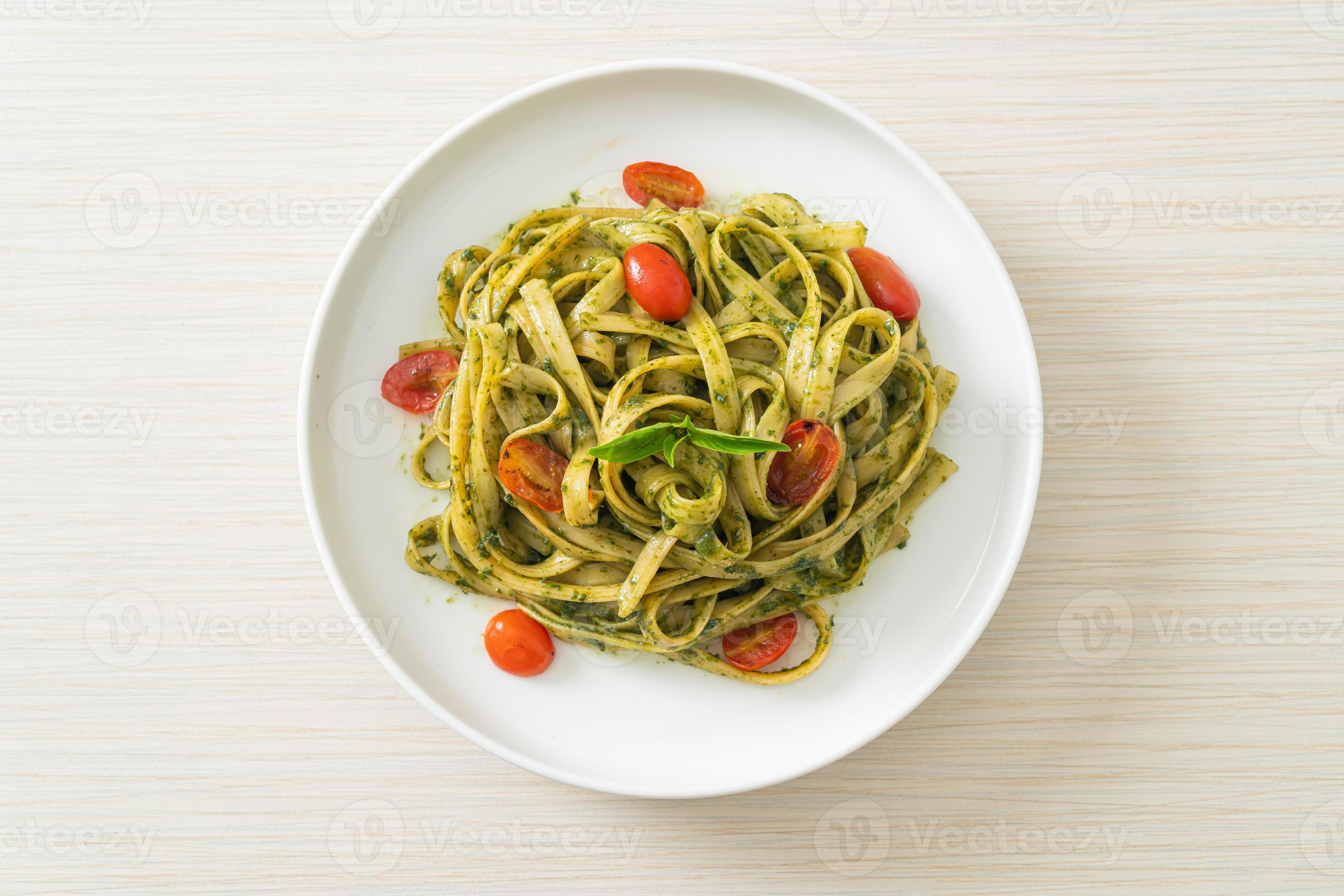 fettuccine spaghetti pasta met pestosaus en tomaten foto