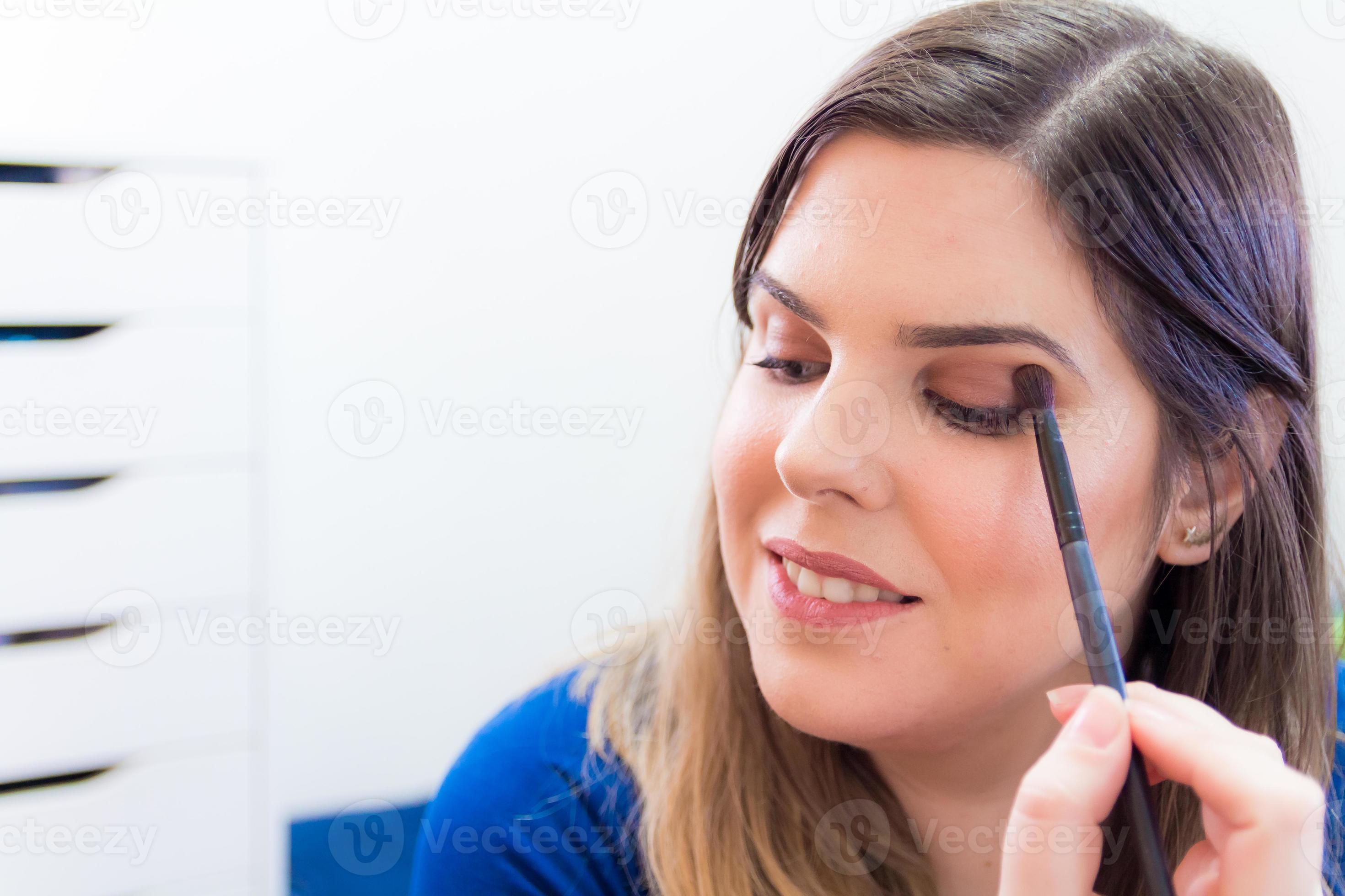 vrouw die make-up aanbrengt in haar slaapkamer foto