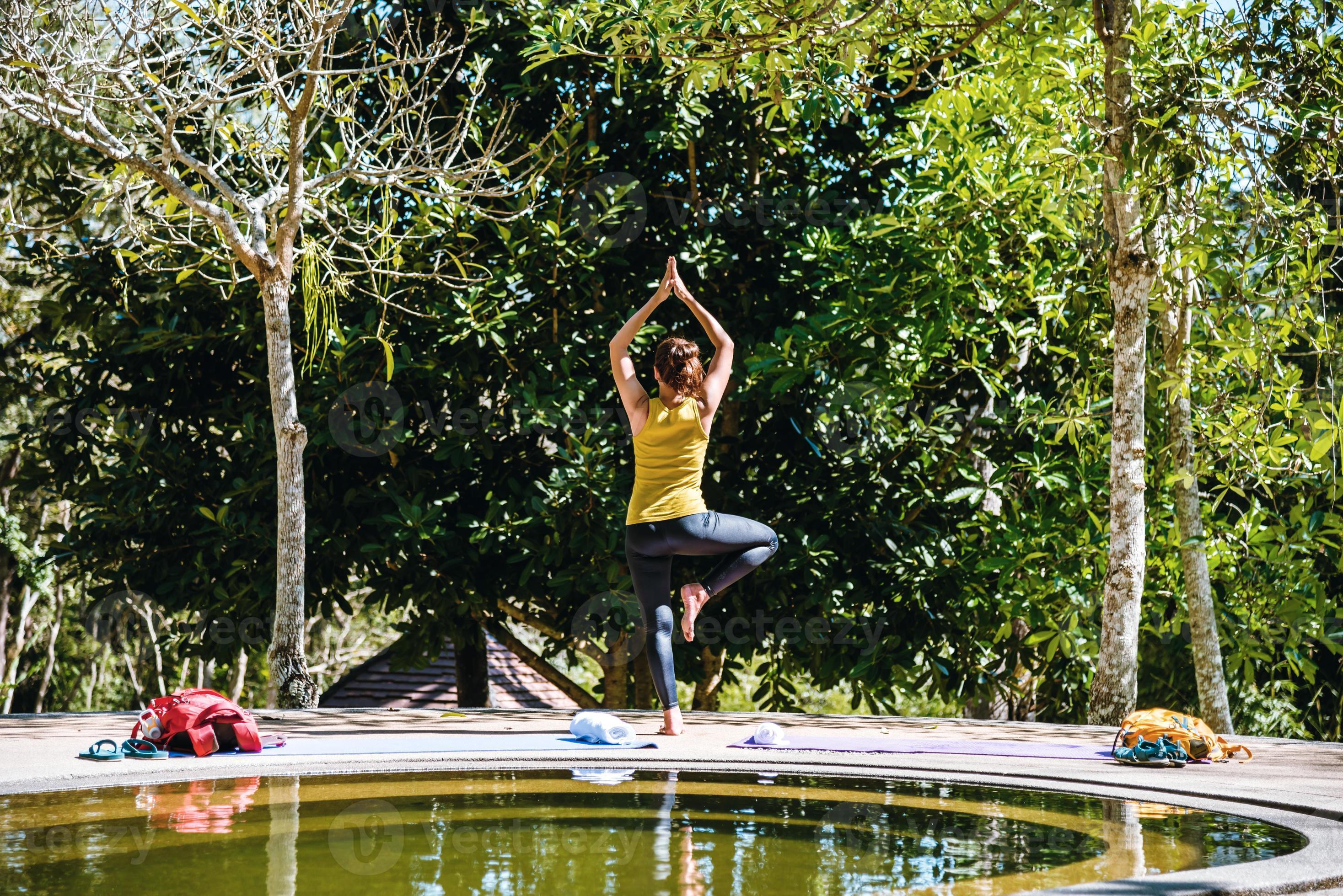 Aziatische vrouwen ontspannen in de vakantie. spelen als yoga in het zwembad warmwaterbron, ontspannen in een natuurlijke warmwaterbronnen.yoga houdingsoefening. foto