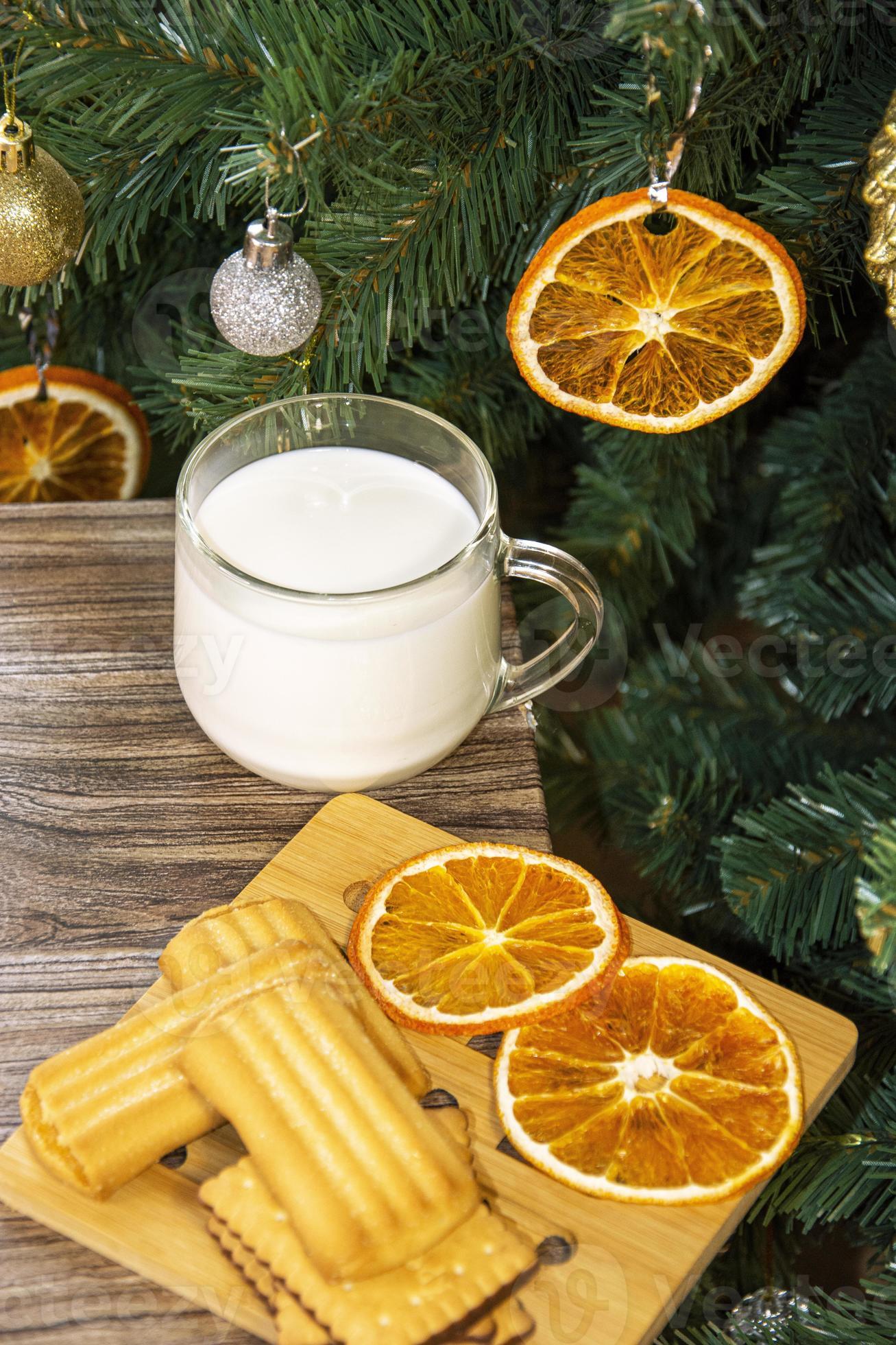 kerstboom met droge stukjes sinaasappel. koekjes met melk voor de kerstman. foto