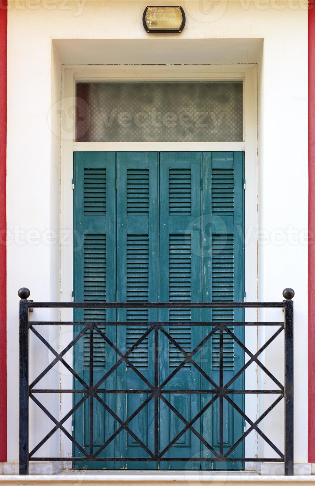 Correspondent verontschuldigen toevoegen aan oude groene houten balkondeuren met houten luiken en metalen staven in het  balkon in griekse stijl. 4704464 Stockfoto