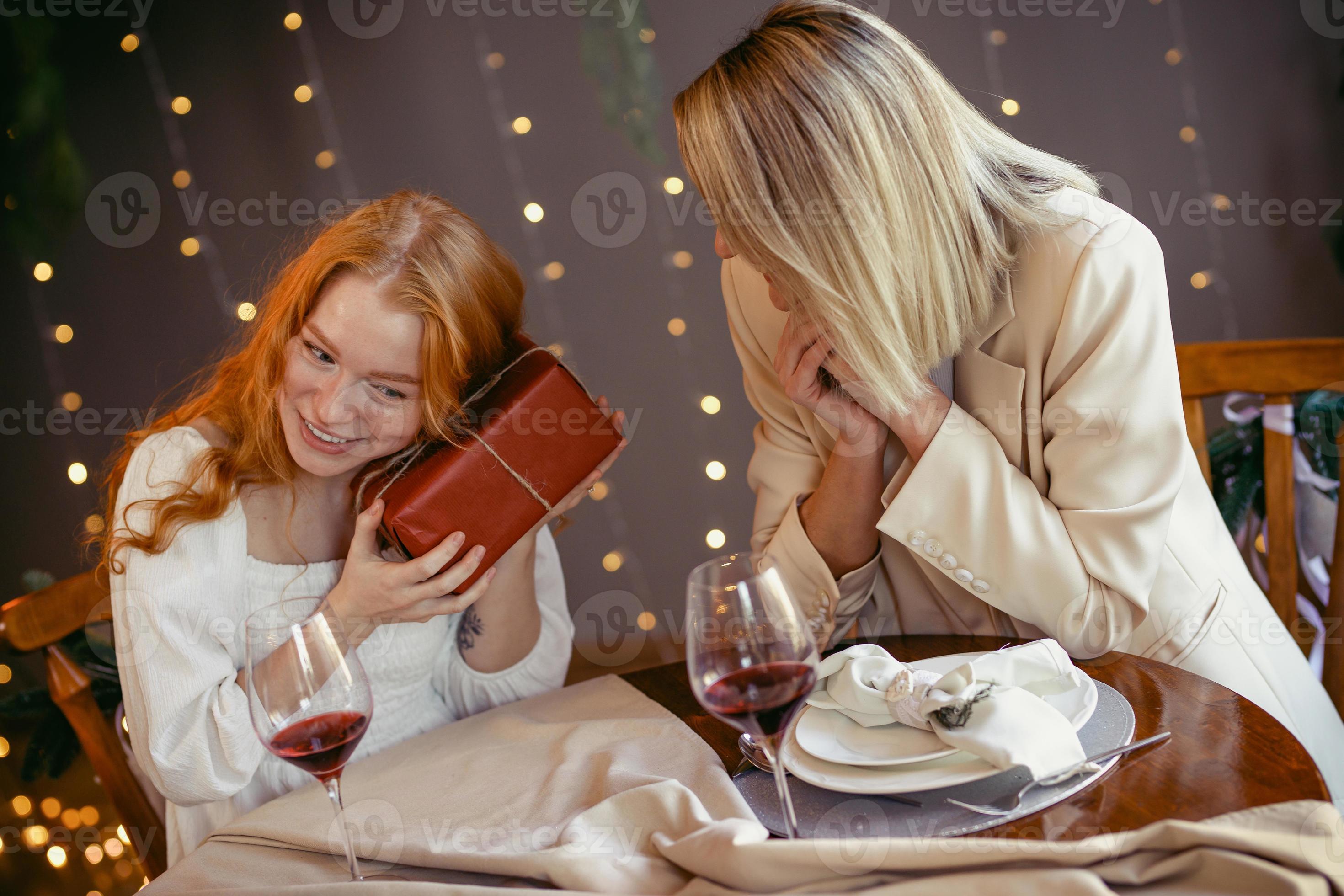 Plantage schapen Maxim lesbisch koppel aan het eten in een restaurant. meisje geeft een cadeau aan  haar geliefde 4951116 stockfoto bij Vecteezy