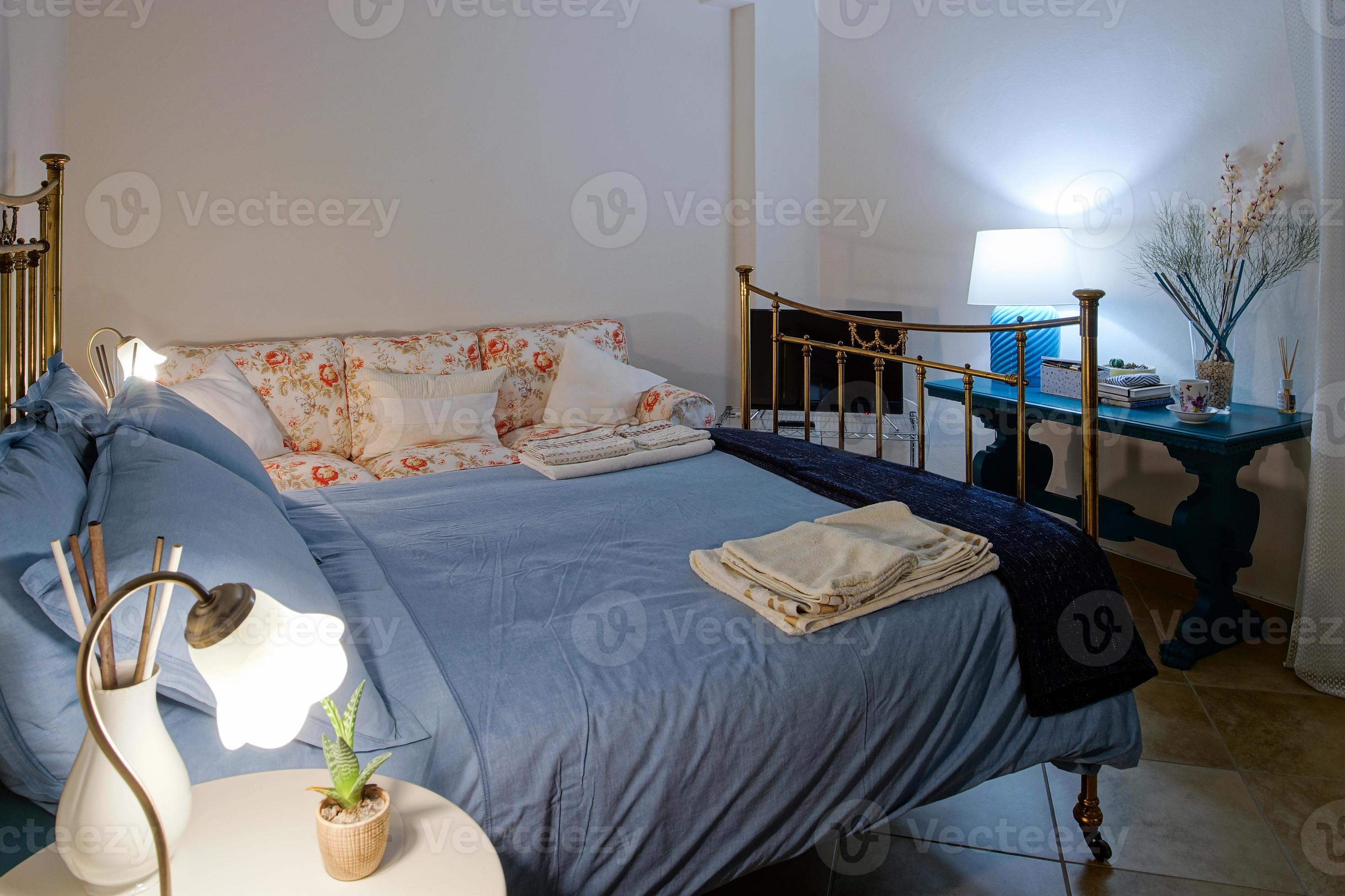 Airco etiquette half acht gezellige comfortabele slaapkamer met een groot bed. nachtlampjes aan elke  kant en zacht licht. 5455456 Stockfoto