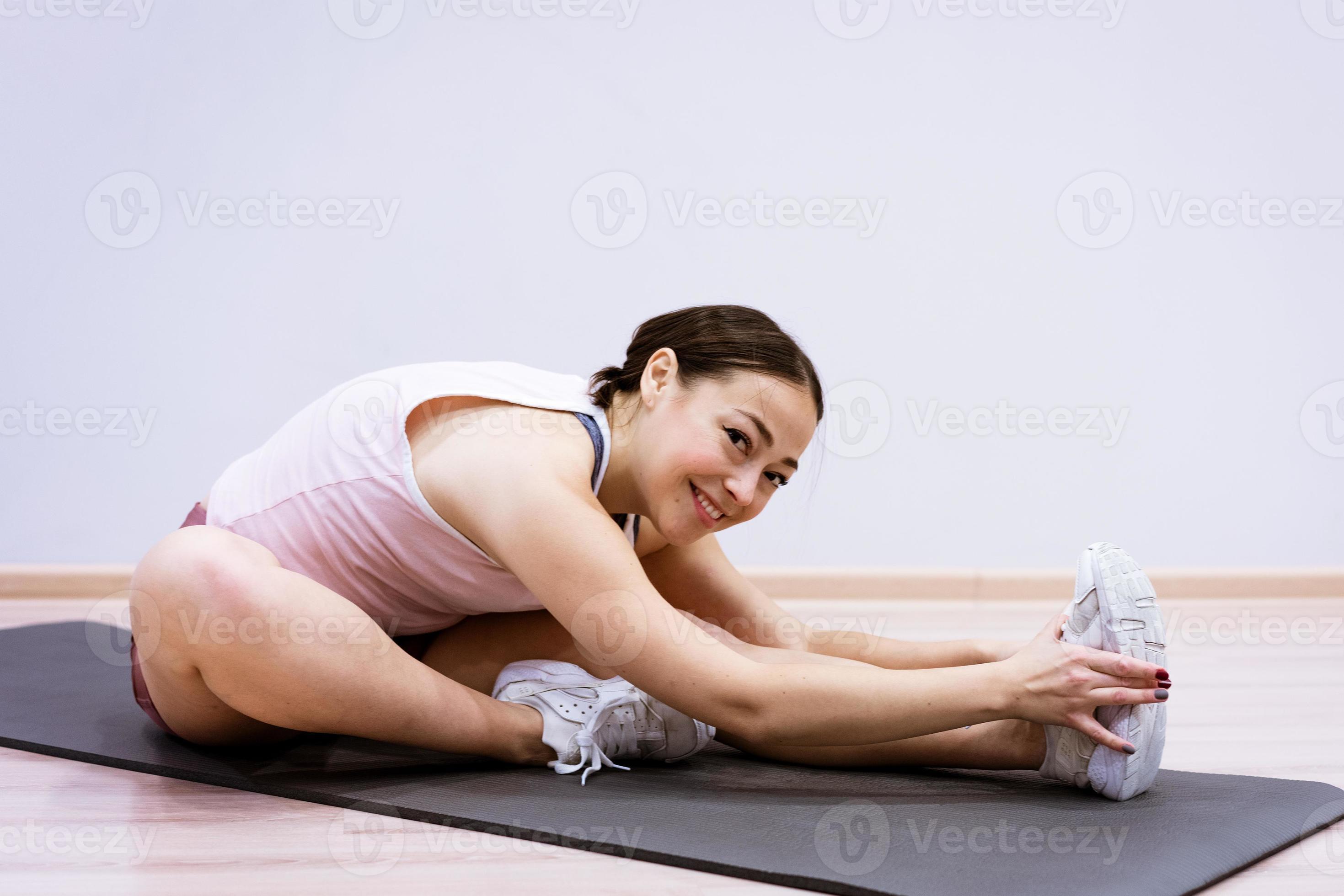 vrouw doet fitness thuis tegen muur achtergrond foto
