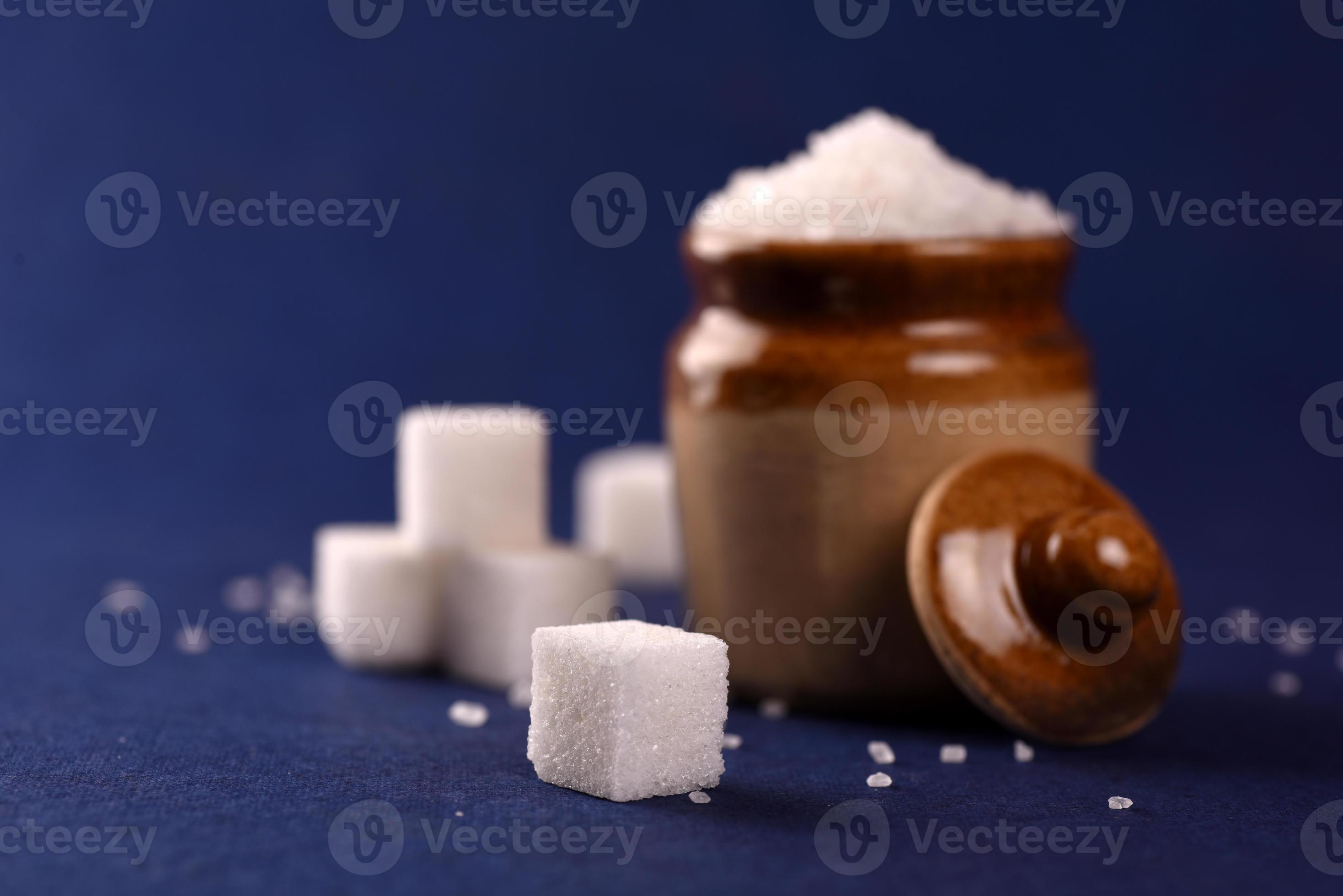 suiker. witte kristalsuiker en geraffineerde suiker op een blauwe achtergrond foto