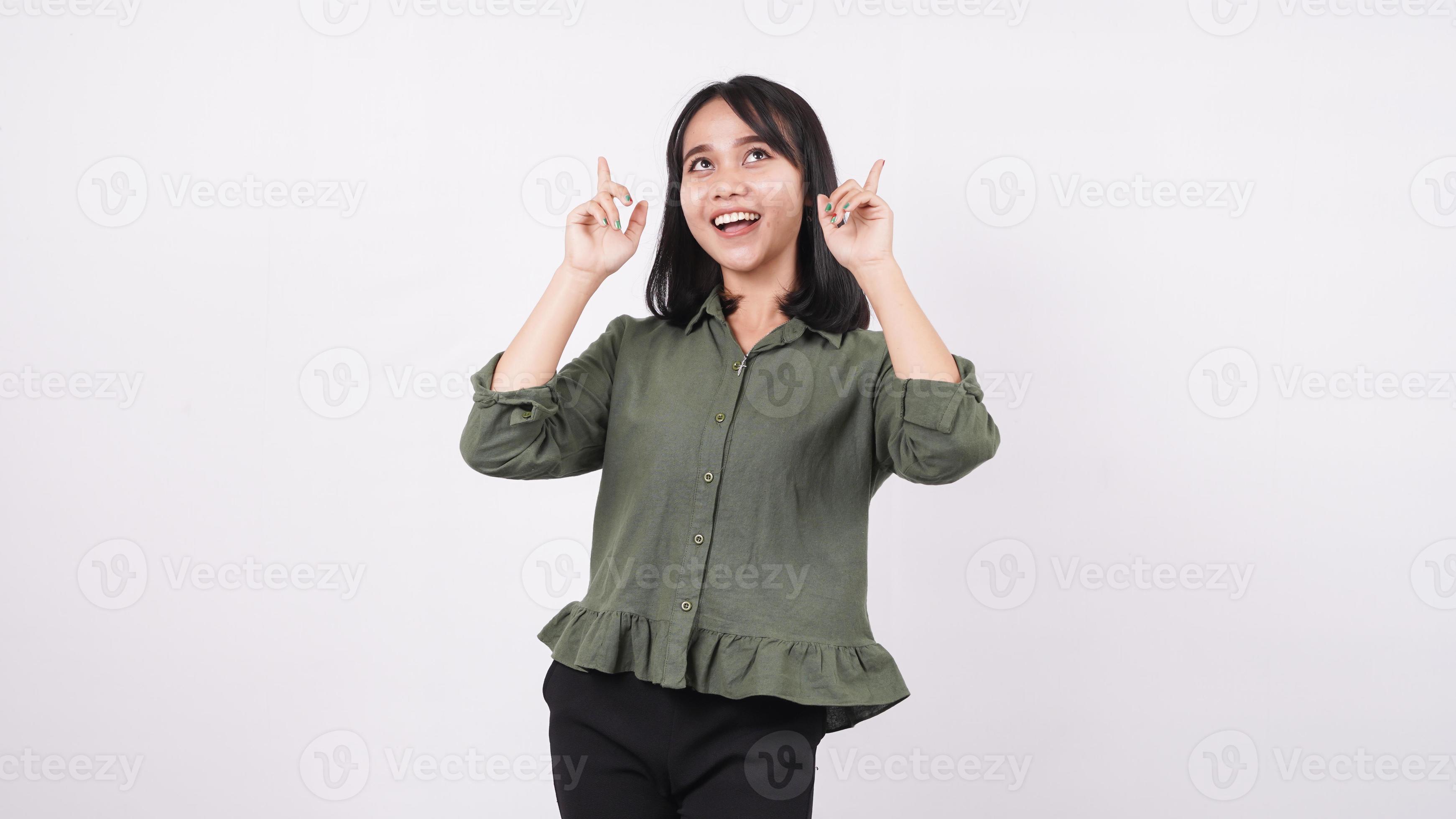 gelukkige aziatische vrouw die op een witte geïsoleerde achtergrond wijst foto