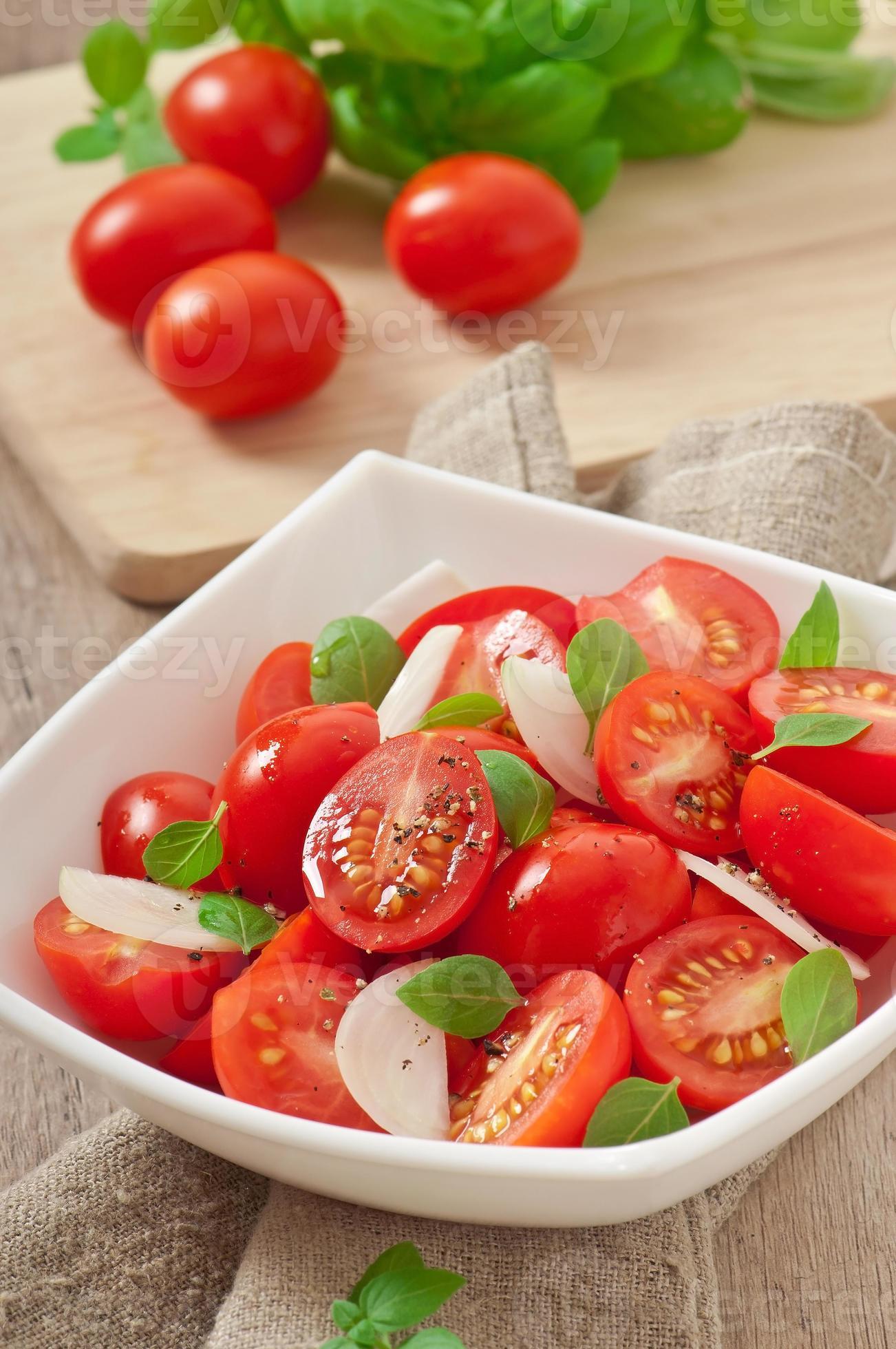 tomaten-kersensalade met basilicum, zwarte peper en ui foto