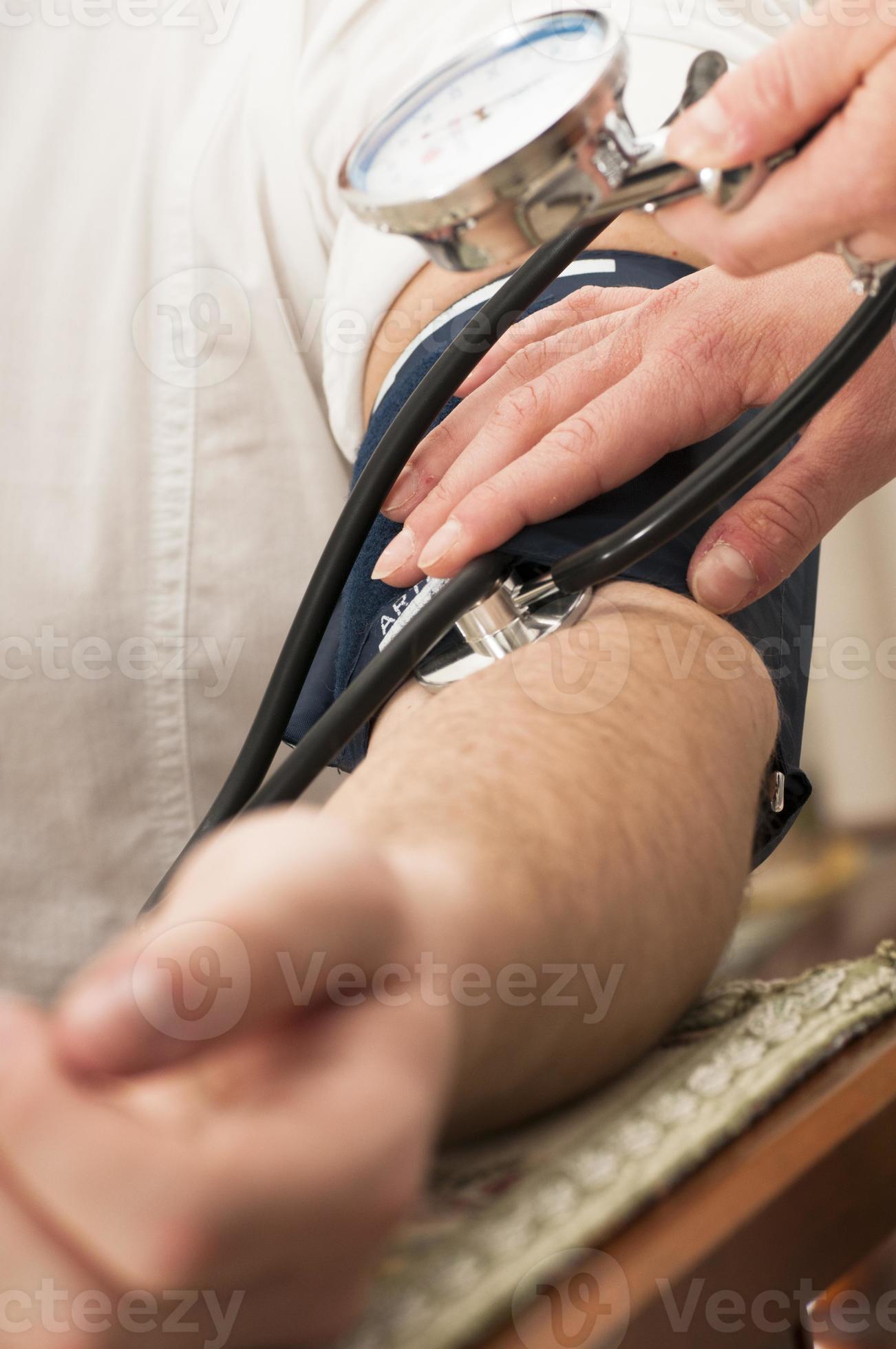 vrouwelijke arts maakt gebruik van een bloeddrukmeter foto