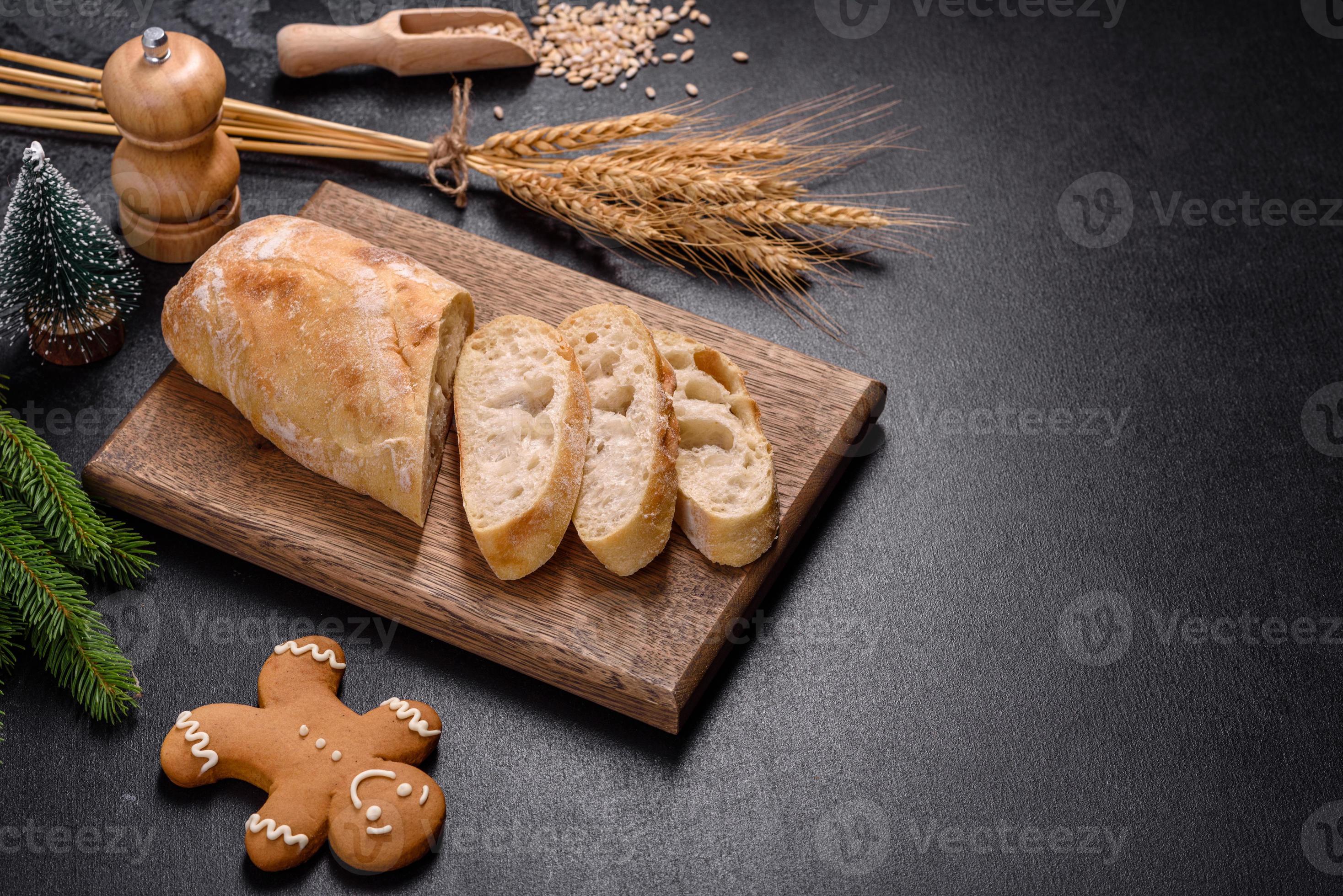 Beeldhouwwerk Helm Nuttig Frans stokbrood brood gesneden op een houten snijplank tegen een donkere  betonnen achtergrond 8374250 Stockfoto