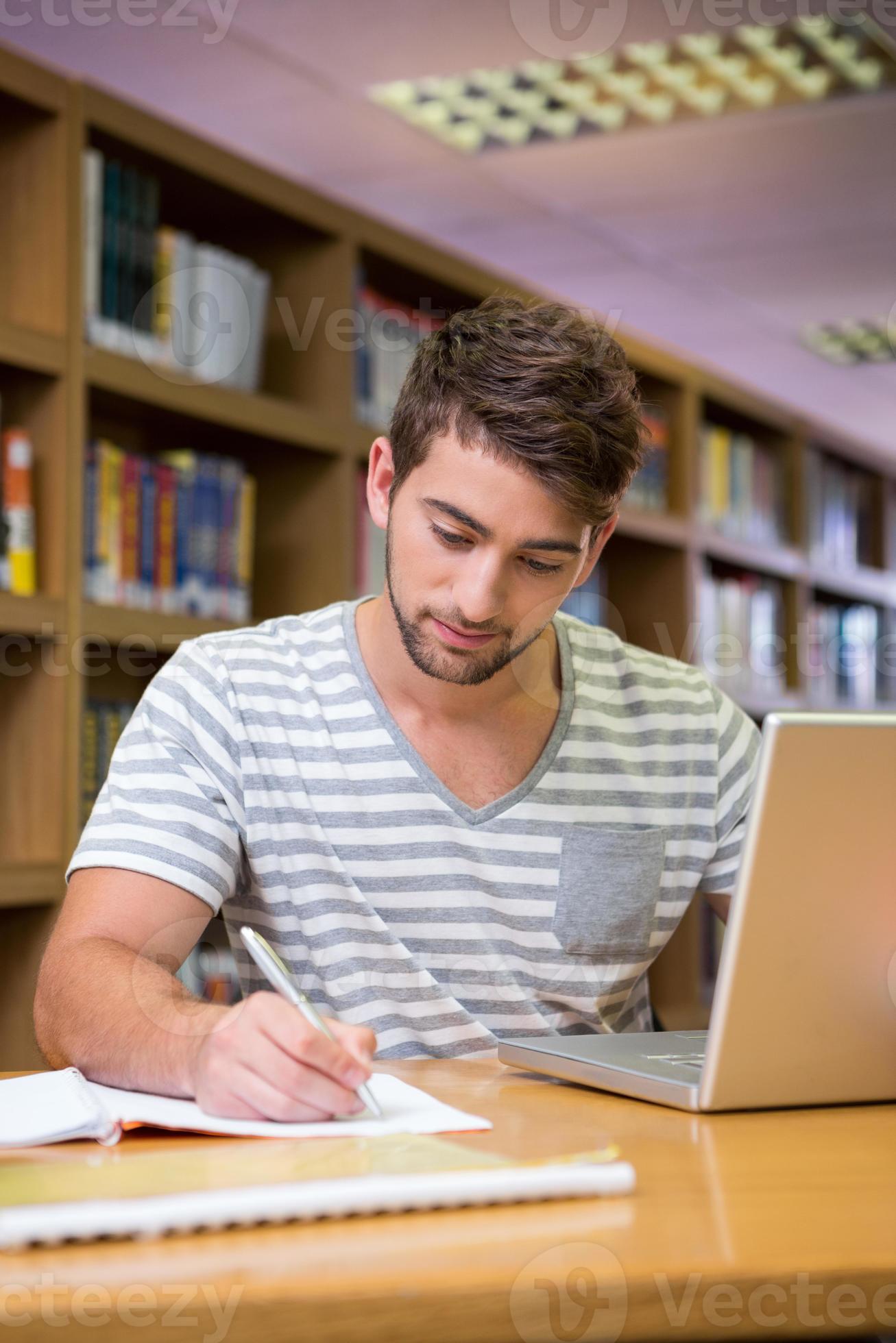 student studeert in de bibliotheek met laptop foto
