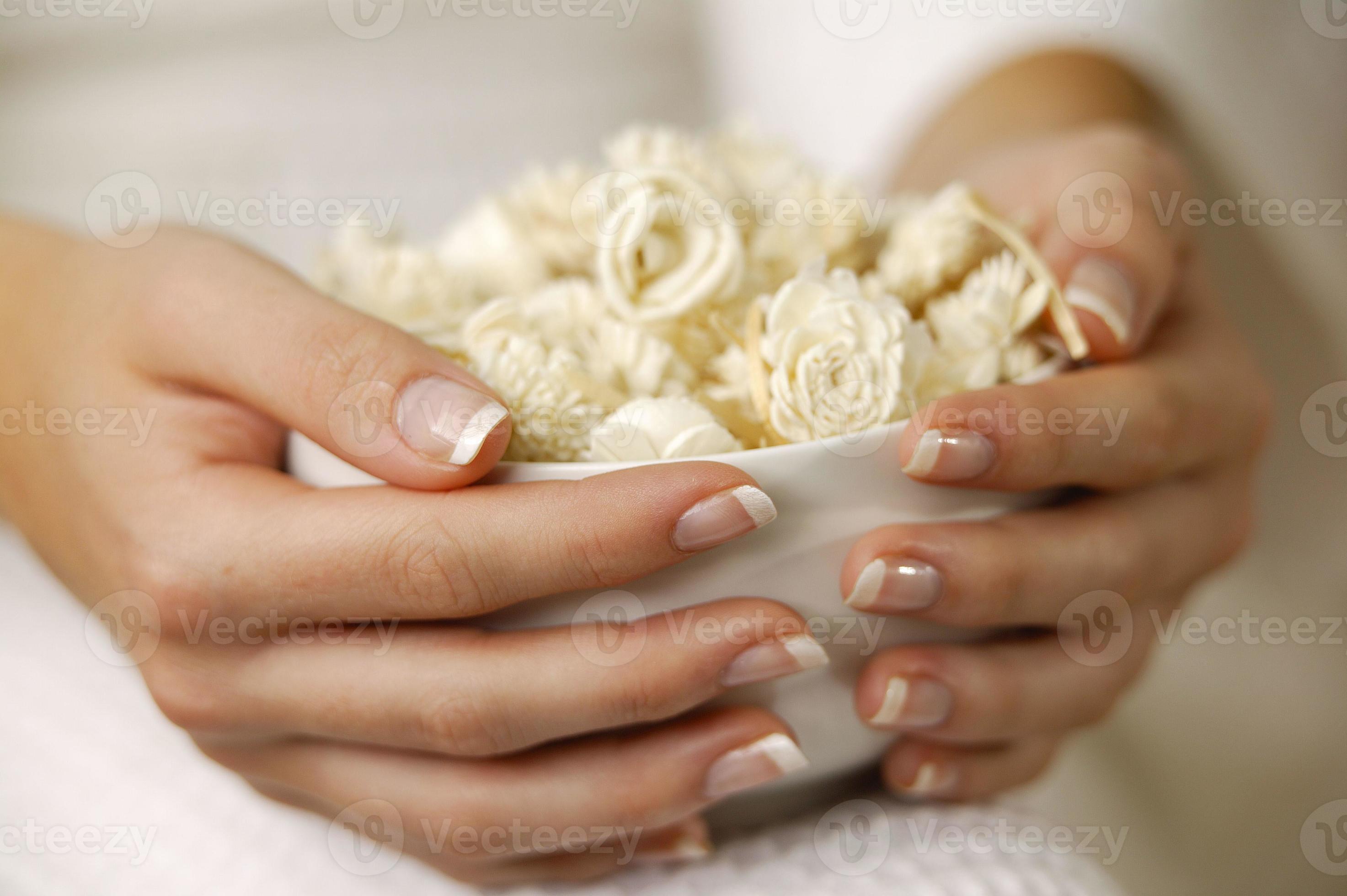 gemanicuurde handen vrouw met kom met bloemen foto