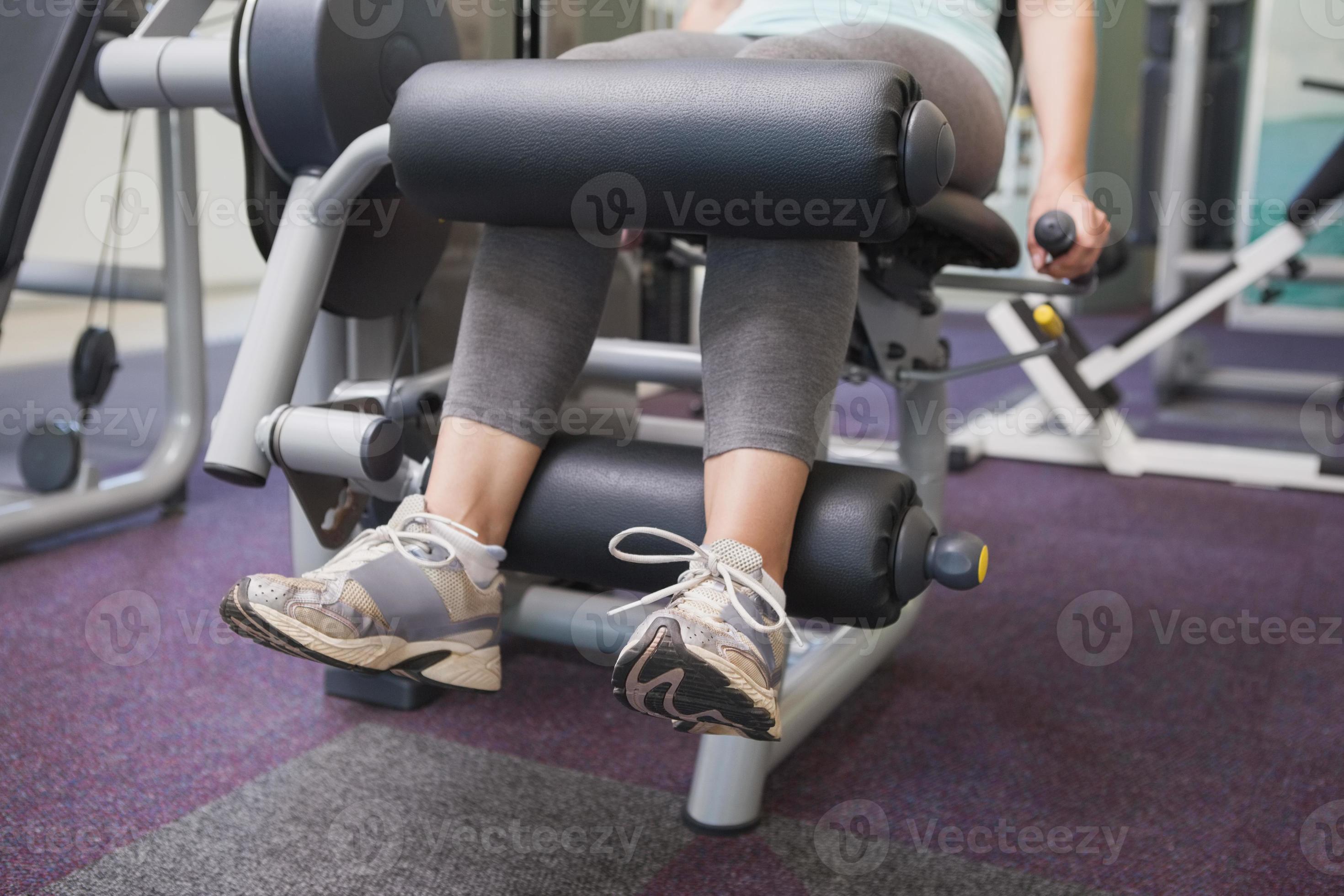 fit vrouw met behulp van gewichten machine voor benen foto