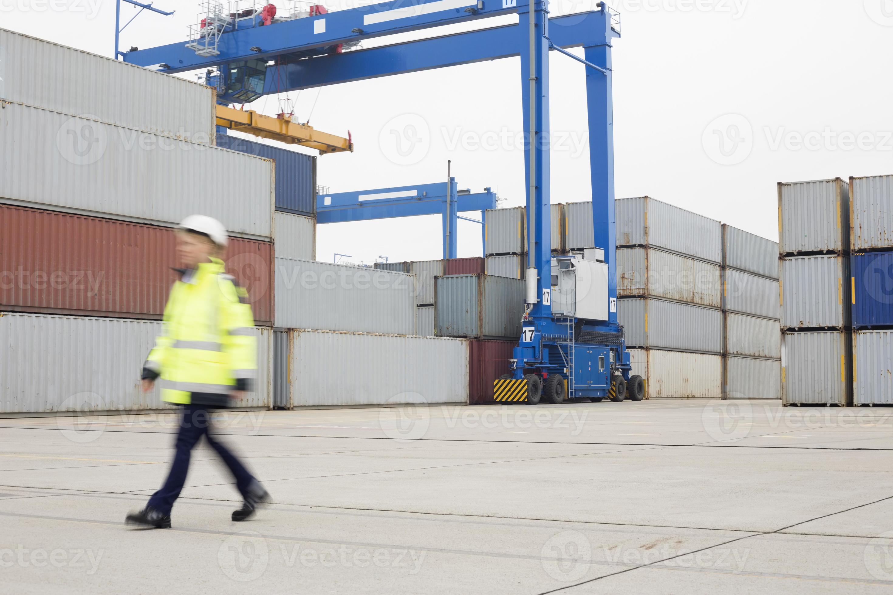 volledige lengte van vrouwelijke werknemer lopen in scheepswerf foto
