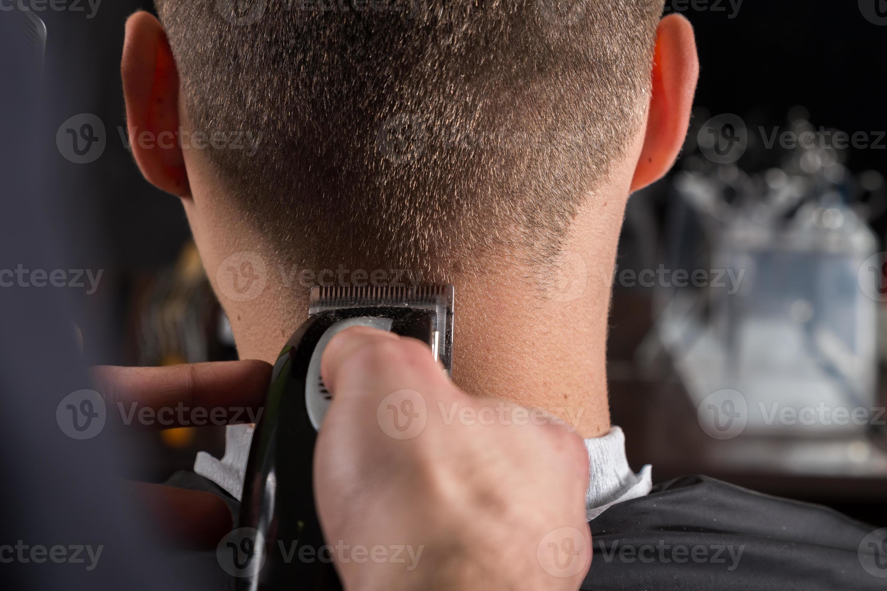 Kapper klanten haar met een tondeuse bij Vecteezy