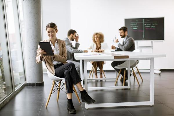 Purper Riskant Ga terug jong vrouw zittend door de tafel met digitaal tablet in modern kantoor in  voorkant van haar team 15706512 Stockfoto