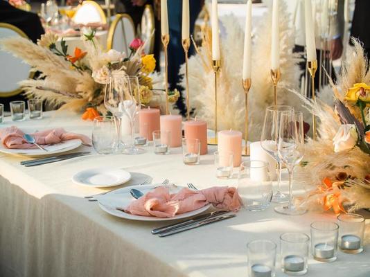 mooi bruiloft decoratie in stad. kaarsen en bloemen en accessoires met boeketten en bril Aan tafel met linnen tafelkleed Aan tafel Aan groen 23034080 stockfoto bij Vecteezy