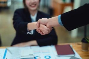 Aziatische ondernemers handdrukken om de overeenkomst tussen de twee bedrijven te feliciteren om investeringen en financiële kracht te verbeteren. deal concept foto