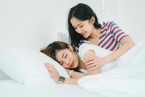 lgbtq, lgbt-concept, homoseksualiteit, portret van twee aziatische vrouwen die gelukkig samen poseren en liefde voor elkaar tonen terwijl ze samen in de slaapkamer zijn foto