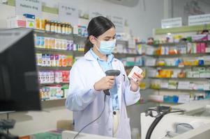 portret van vrouwelijke apotheker die gezichtsmasker draagt in een moderne apotheekdrogisterij. foto