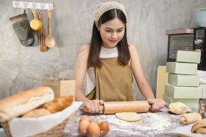 jonge mooie vrouw bakt in haar keuken, bakkerij en coffeeshopbedrijf foto