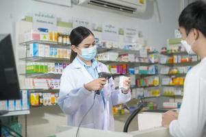 portret van vrouwelijke apotheker die gezichtsmasker draagt in een moderne apotheekdrogisterij. foto