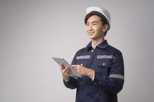 portret van mannelijke ingenieur die een beschermende helm over witte achtergrond draagt studio. foto