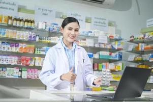 vrouwelijke apotheker die klant adviseert via videogesprek in een moderne apotheekdrogisterij. foto