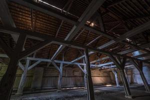 binnen donkere verlaten verwoeste houten rottende hangar met rottende kolommen foto