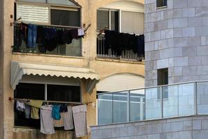 gewassen linnen droogt op straat buiten het raam van het huis. foto