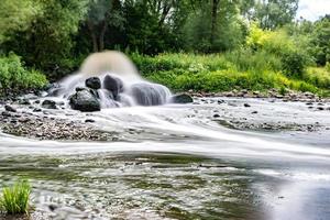 mengzone van afvalwaterlozing van stedelijk afvalwater. vervuiling van de rivier. stad stortplaatsen. lange blootstelling foto