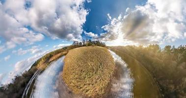 kleine planeettransformatie met kromming van de ruimte. sferische luchtfoto 360 uitzicht panorama aan de oever van het meer in de zonnige zomer met geweldige wolken. foto