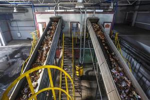 bewegende transportband op moderne afvalverwerkingsfabriek. gescheiden en sorteren van afvalinzameling. recycling en opslag van afval voor verdere verwijdering. foto