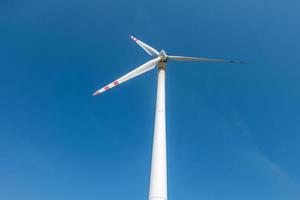 roterende bladen van een windmolenpropeller op blauwe hemelachtergrond. opwekking van windenergie. pure groene energie. foto