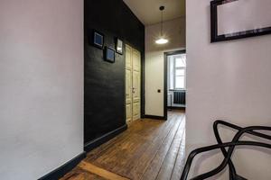 lange gang in het interieur van de inkomhal van vintage appartementen met deuren in het loft-interieur met bakstenen muren foto