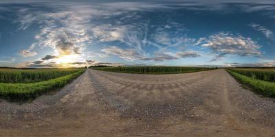 volledig naadloos bolvormig panorama 360 graden hoekzicht op onverharde weg tussen velden in zomeravond zonsondergang met geweldige wolken in equirectangular projectie, skybox vr ar virtual reality-inhoud foto