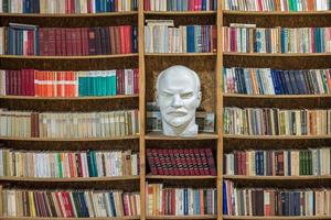 buste het hoofd van de proletariaat leider lenin in de bibliotheek op een plank met boeken foto