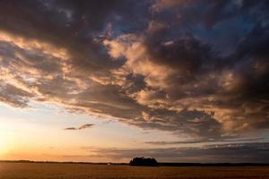 blauwe rode hemelachtergrond met avond pluizige krullende rollende wolken met ondergaande zon. goed winderig weer foto