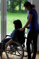 verzorger duwende rolstoel met gehandicapte vrouw