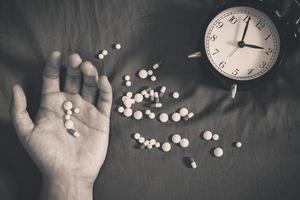 overdosis man hand en drugs op bed 's nachts foto