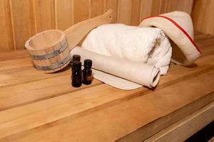 traditioneel oud russisch badhuis spa concept. interieur details Finse sauna stoomkamer met traditionele sauna accessoires set wastafel handdoek aroma olie schep vilt. ontspannen land dorp bad concept. foto