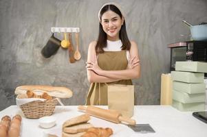 jonge mooie vrouw bakt in haar keuken, bakkerij en coffeeshopbedrijf foto