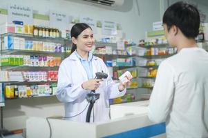 vrouwelijke apotheker die klant adviseert over drugsgebruik in een moderne apotheekdrogisterij. foto