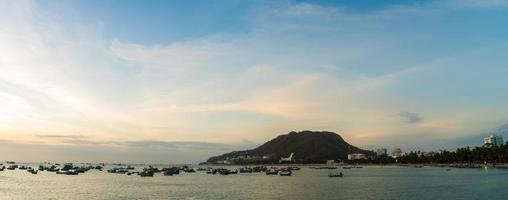 vung tau luchtfoto van de stad met prachtige zonsondergang en zoveel boten. panoramisch uitzicht op de kust van vung tau van bovenaf, met golven, kustlijn, straten, kokospalmen en tao phung-berg in vietnam. foto