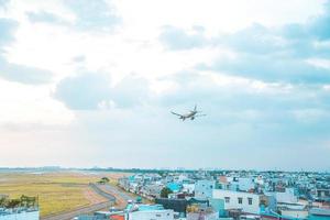 Ho Chi Minh-stad, Vietnam - 12 februari 2022 vliegtuig vliegt over stedelijke gebieden en bereidt de landing voor op de internationale luchthaven Tan Son Nhat en vertrekt op TSN Airport foto