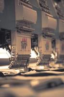 moderne en automatische hoogtechnologische naaimachine voor het productieproces van textiel of kleding voor het maken van kleding in de industrie. digitale textielindustrie. computergestuurd borduren. foto