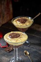 vanille en chocoladepudding in hoog glas met geraspte chocoladestukjes foto